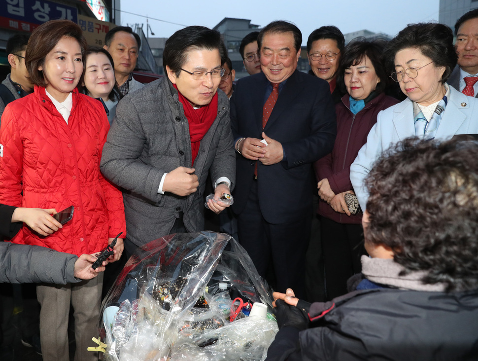 자유한국당 황교안 대표가 5일 새벽 서울 남대문시장을 방문해 시장 상인과 인사 후 상인이 파는 김밥을 사서 맛보고 있다. 연합뉴스