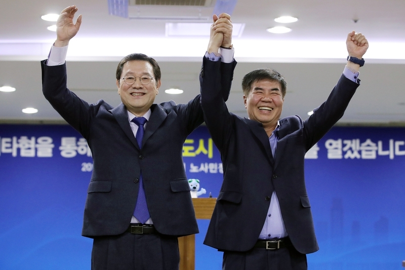 지난 1월 30일 오후 광주시청 중회의실에서 이용섭 광주시장(왼쪽)과 윤종해 한국노총 광주전남본부 의장이 광주시 노사민정협의회 결과를 발표하고 손을 들어 올리고 있다. 연합뉴스