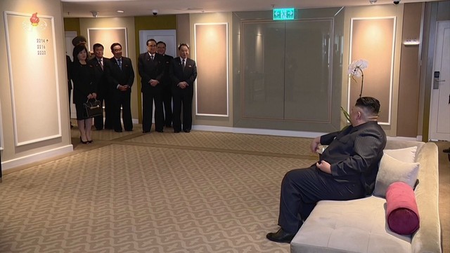 북한 조선중앙TV가 6일 방송한 기록영화 화면 가운데 김 위원장이 2월26일 하노이 멜리아 호텔에 도착해 소파에 앉아 멀찌감치 떨어진 문 앞에서 서 있는 북한 간부들과 대화를 나누는 장면. 연합뉴스