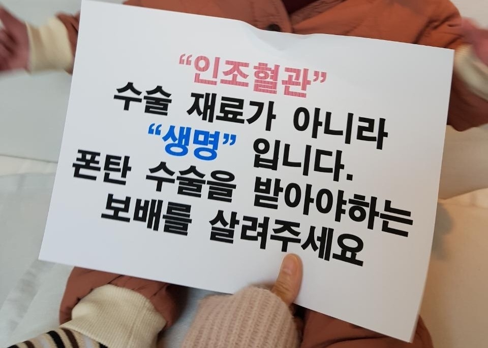 선천성 심장병을 앓고 있는 이보배(2)양의 어머니가 최근 고어사의 인공혈관 공급 중단과 관련해 공급 재개를 호소하는 글을 아이와 함께 찍어 <한겨레>에 보냈다. 어머니 천새롬씨 제공