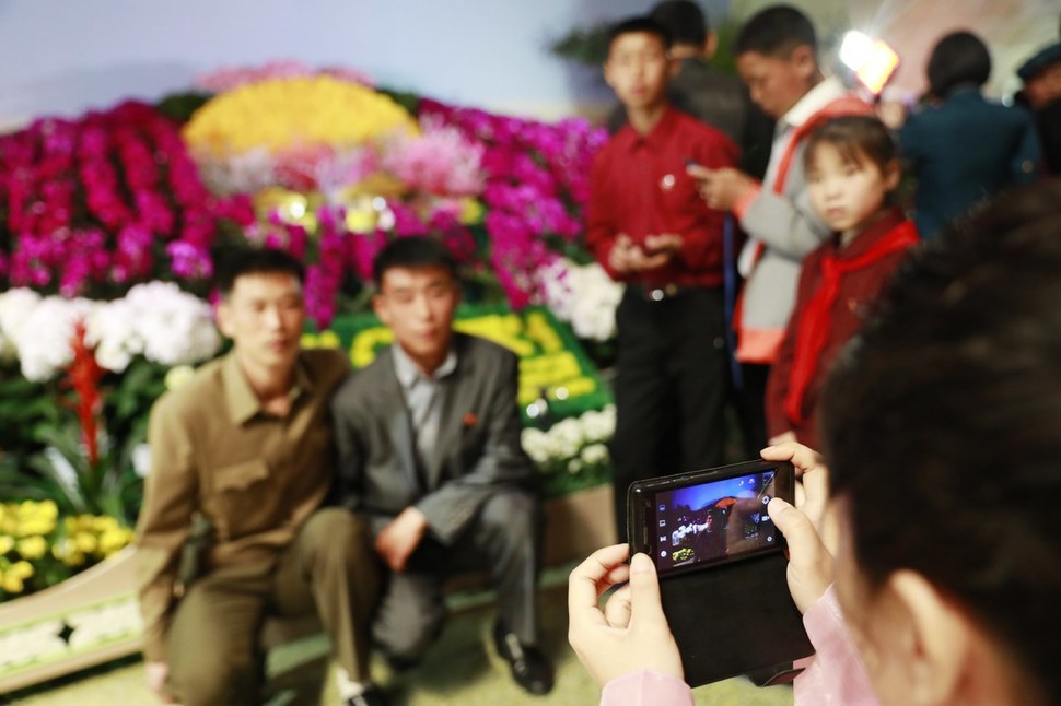 북한 주민들이 2017년 4월16일 평양에서 열린 김일성 탄생 105주년 기념 꽃 전시회 행사에서 휴대전화로 기념사진을 찍고 있다. 평양/EPA 연합뉴스