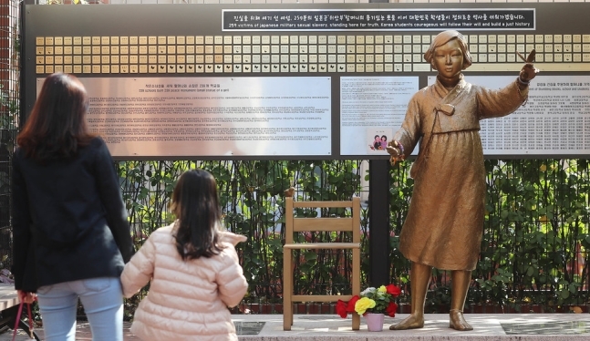 지난해 11월4일 낮 서울 중구 정동 프란치스코 교육회관 앞에 설치된 위안부 피해 할머니들의 기록이 담긴 동판을 시민들이 살펴보고 있다. 길을 지날 때마다 한번씩 보고 희생자들을 기억하자는 의미의 이 ‘걸림돌’은 이화여고 등 전국 46개교 학생들이 참여해 259개의 동판으로 제작되었다. 동판 개수는 정부에 등록된 240명의 할머니와 함께 중국, 일본, 북한에 있는 할머니 19명을 더한 것이다. 신소영 기자 viator@hani.co.kr