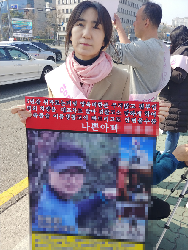 ‘양육비해결모임’ 회원인 최정옥(43)씨가 26일 서울 국회 앞에서 이혼 뒤 양육비를 지급하지 않는 전 남편 ㄱ씨의 얼굴이 공개된 팻말을 들고 양육비 미지급자를 제재하는 내용을 담은 법안을 통과시켜달라고 국회에 촉구하고 있다.