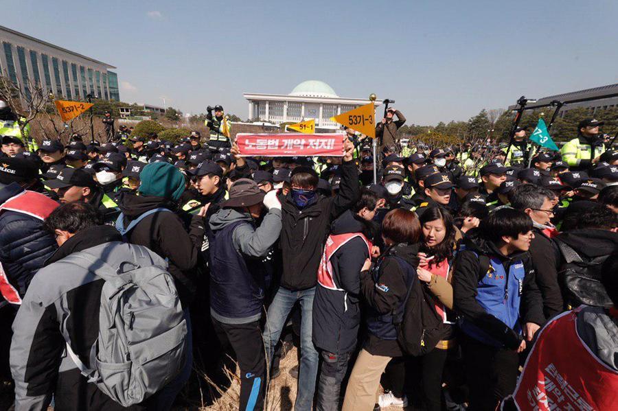 3일 오전 국회 정문에서 노동법 개악 저지 등을 촉구하고 국회 환경노동위원회 고용노동소위 참관을 요구하며 민주노총 관계자들이 담장을 넘어 국회 경내로 진입을 시도하고 있다. 민주노총 제공