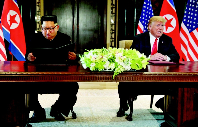 지난해 6월12일 싱가포르에서 사상 첫 북-미 정상회담을 마치 뒤 김정은 국무위원장과 도널드 트럼프 미국 대통령이 공동성명 서명식을 치르고 있다. 연합뉴스