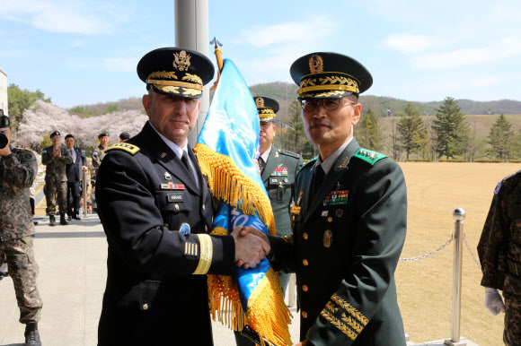 남영신 신임 지상작전사령관이 16일 경기도 용인 지상작전사령부 연병장에서 열린 취임식에서 로버트 에이브럼스 한-미연합사령관으로부터 지상구성군사령부기를 넘겨받고 있다. 국방부 제공