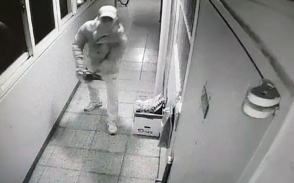 ‘진주 아파트 참사’ 피의자 안아무개씨가 지난달 12일 저녁 윗집 현관문에 오물을 뿌리고 있다. 윗집 주민이 설치한 폐회로텔레비전에 찍힌 화면. 경남경찰청 제공