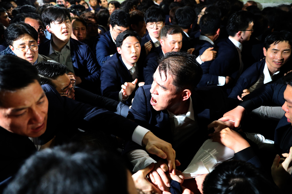 경호권 발동으로 출동한 국회 경위들이 25일 저녁 국회 의안과 앞에서 자유한국당 의원, 보좌관들에게 둘러싸여 제지당하고 있다. 강창광 기자