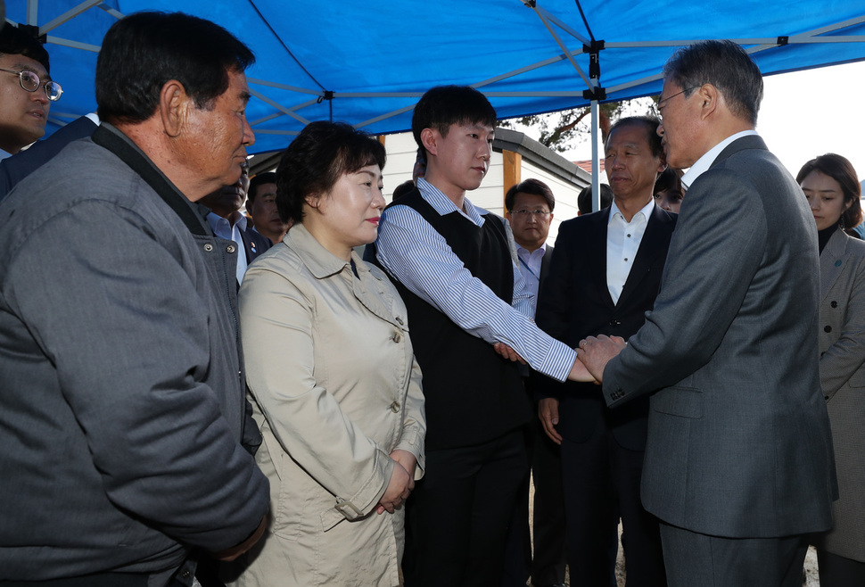 문재인 대통령이 26일 오전 산불피해 복구현장인 강원 고성군 토성면 성천리 마을을 찾아 산불진화에 참여한 소방관(가운데) 및 공무원, 피해주민을 격려하고 있다. 고성/김정효 기자