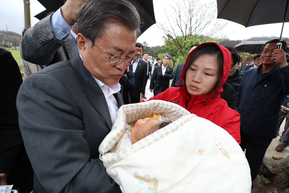 문재인 대통령이 26일 오전 산불피해 복구현장인 강원 고성군 토성면 성천리 마을을 찾아 태어난 지 한 달된 피해주민의 아기를 안아 살피고 있다. 아기의 엄마는 베트남 출신 결혼이주민이다. 고성/김정효 기자 hyopd@hani.co.kr