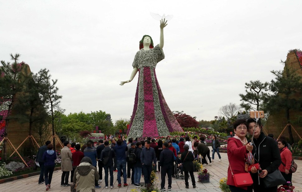 26일 경기 고양시 일산호수공원 내 테마별 정원에서 관람객들이 꽃으로 장식된 거대한 ‘평화의 여신’ 앞에서 기념촬영을 하고 있다. 고양/박종식 기자