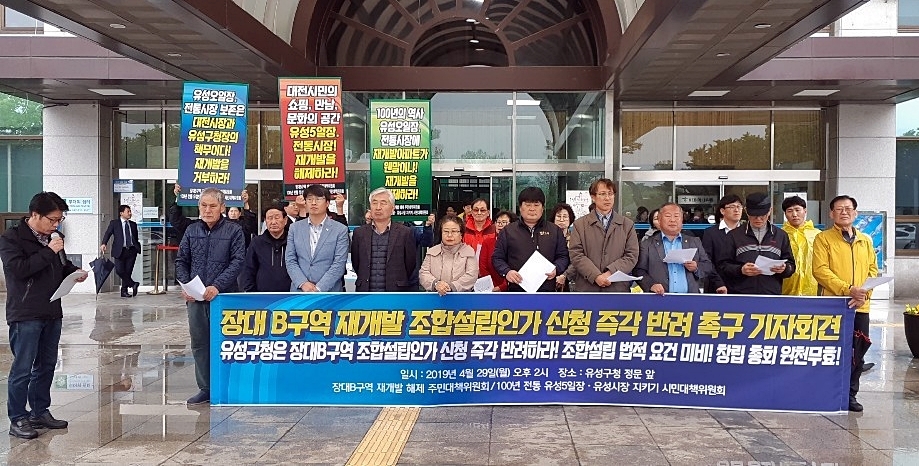 유성5일장·유성시장 지키기 시민대책위원회 등은 29일 오후 대전 유성구청 앞에서 ‘재개발 조합설립 인가를 반려하라’는 기자회견을 열고 있다. 장대 비구역 재개발 해제 주민대책위원회 제공
