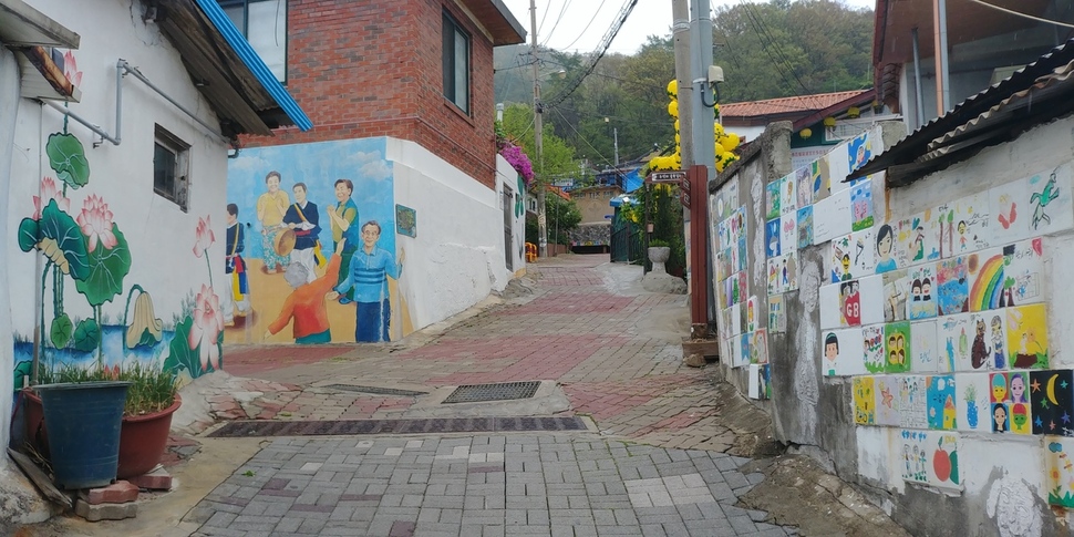 25일 오후 청주 수암골 벽화 골목. 골목은 텅 비었지만 벽화 속 정겨운 모습이 주민들 대신하는 듯하다. 오윤주 기자