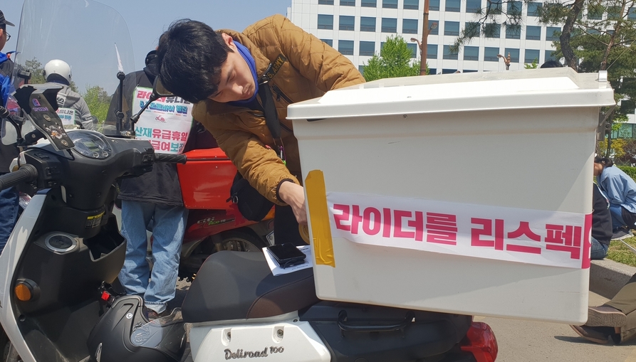 1일 오후 1시 서울 영등포구 국회의사당 앞에서 열린 배달 대행 업체 배달기사들의 노조 ‘라이더 유니온’ 출범 총회에서 배달기사 박상빈(32)씨가 자신의 오토바이에 ‘라이더를 리스펙’이라고 적힌 띠를 두르고 있다. 오연서 기자