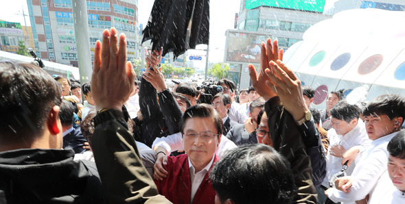 `물세례%!^a 받는 황교안자유한국당 황교안 대표를 비롯한 의원들이 3일 오전 광주광역시 송정역 광장에서 열린 %!^a%!^a문재인 STOP! 광주시민이 심판합니다%!^a%!^a 행사를 마친 뒤, 시민 단체들의 거센 항의를 받으며 역사로 이동하고 있다. 광주/연합뉴스