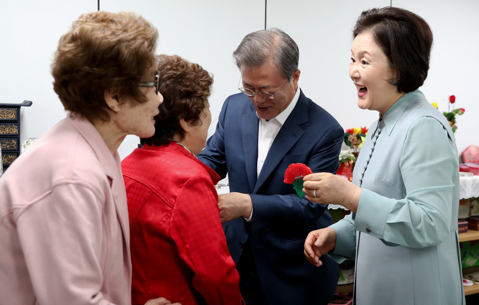 문재인 대통령과 부인 김정숙 여사가 7일 오전 서울 금천구 독산동 치매안심센터에서 직접 만든 종이 카네이션을 어르신들 가슴에 달아드리고 있다. 김정효 기자