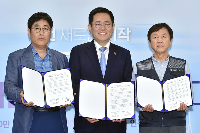 박남춘 인천시장이 14일 시청 접견실에서 열린 ‘시내버스 노·정 상생 협약서 체결식’에서 김성태 전국자동차노련 인천지역노동조합 위원장과 협약서를 체결한 뒤 기념촬영을 하고 있다. 인천시 제공