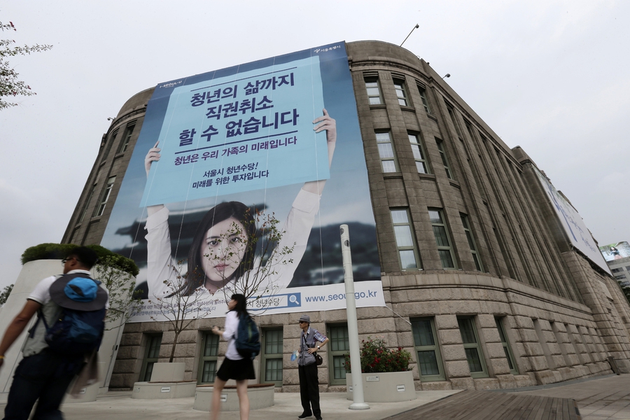 서울시 청년활동지원사업(청년수당)에 대한 정부의 직권취소 조처를 비판하는 대형 펼침막이 2016년 8월14일 오후 서울 중구 태평로 서울도서관 외벽에 걸려있다. 서울시는 청년수당에 대한 정부의 직권최소에 항의해 서울시청과 길거리, 지하철 등에 대형 현수막과 광과판을 내걸었다. 정부도 서울시의 홍보전에 대응해 정부서울청사 외벽에 서울시 청년수당에 대한 정부의 입장을 밝히는 대형 펼침막을 내걸었다. 김명진 기자 littleprince@hani.co.kr