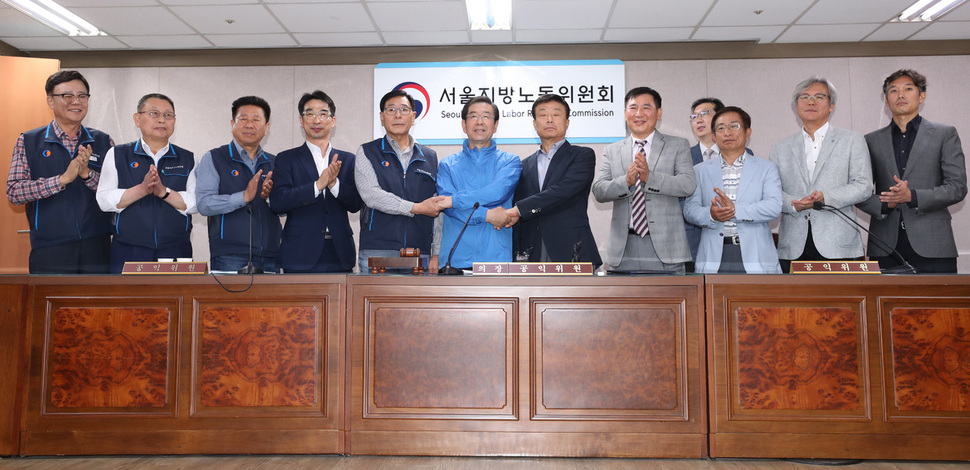 서울 시내버스 노사가 15일 파업을 불과 2시간 앞두고 임금단체협약 협상을 타결, 서정수 노조위원장(왼쪽 다섯번째부터), 박원순 서울시장, 피정권 운송사업조합 이사장 등이 기념촬영을 하고 있다. 연합뉴스