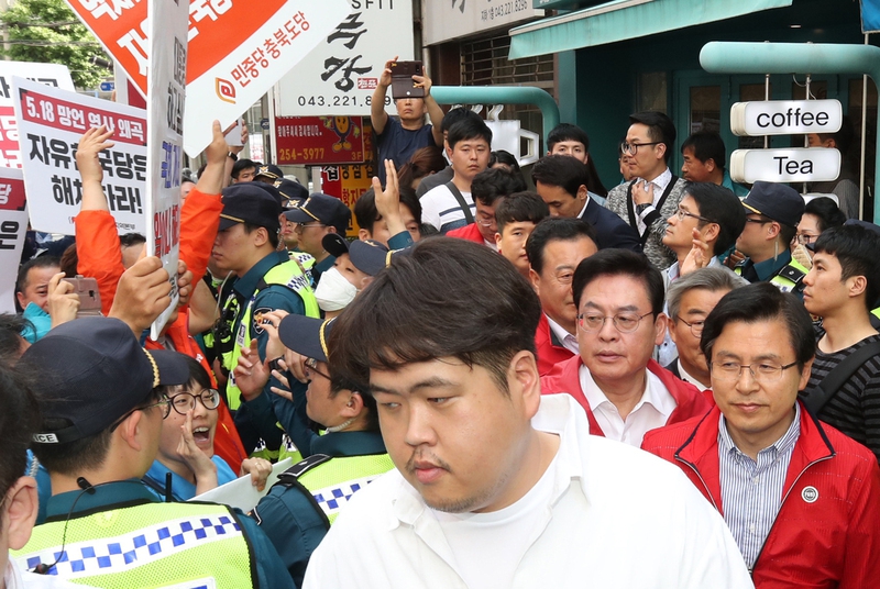 자유한국당 황교안 대표가 지난 14일 오후 충북 청주시 상당구 한 커피점에서 학부모 간담회를 마치고 나가던 중 민주노총 충북지역본부 조합원들이 자유한국당 해체를 요구하며 시위를 벌이자 경찰의 도움을 받아 빠져나가고 있다. 연합뉴스