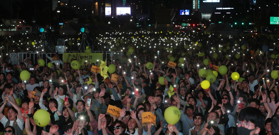 노무현 전 대통령 서거 10주기를 앞두고 18일 저녁 서울 광화문광장에서 서울 시민문화제가 열려 참가한 시민들이 노란 풍선과 손팻말, 불 켠 스마트폰을 들어올리고 있다. 강창광 기자 chang@hani.co.kr