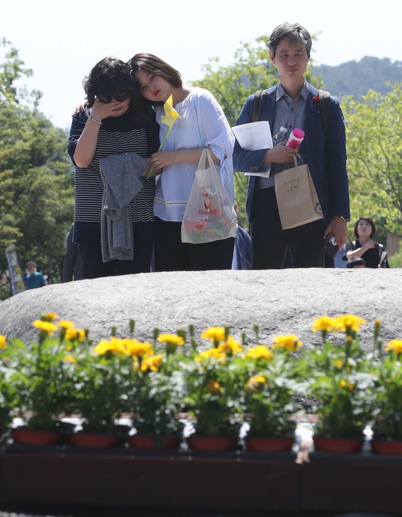 노무현 전 대통령 서거 10주기 추도식을 하루 앞둔 22일 오후 경남 김해시 진영읍 봉하마을에서 참배객들이 노 전 대통령의 묘역에서 애도하고 있다. 김해/박종식 기자