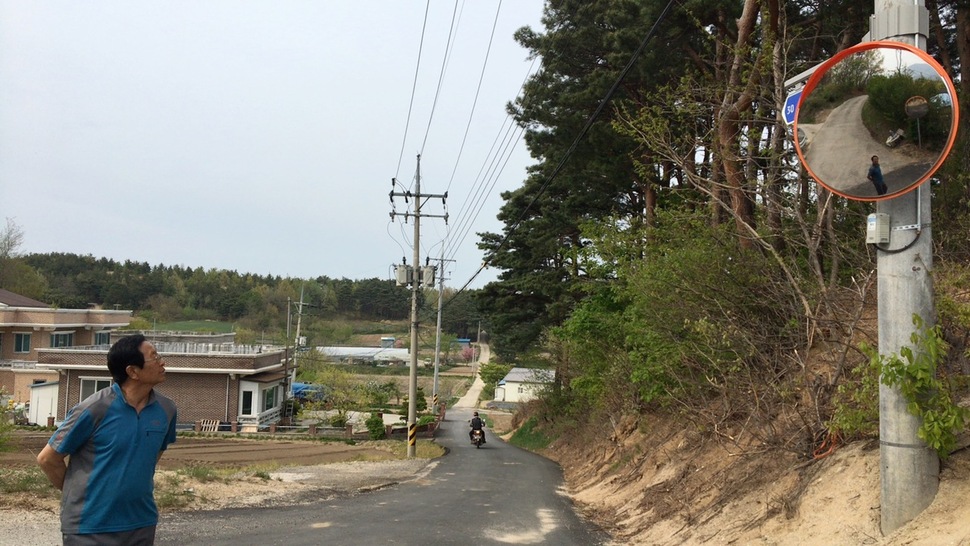 죽왕면 삼포2리 함형복 이장이 산불 당일(4월4일) 주민 박석전씨(사진 왼쪽 단층 건물 거주)가 쓰러져 있던 전신주 쪽을 올려다 보고 있다.