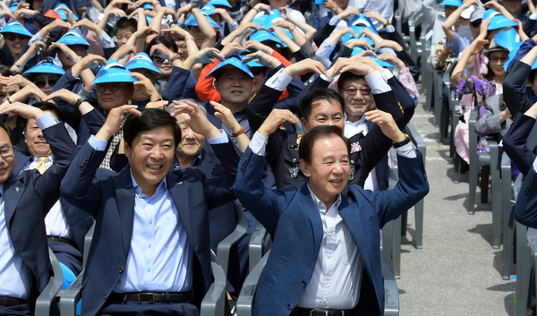 김홍신(앞줄 왼쪽 셋째) 작가 등이 8일 열린 ‘김홍신 문학관’ 개관식에서 시민과 함께 개관 축하 손 하트를 만들고 있다.   논산시 제공