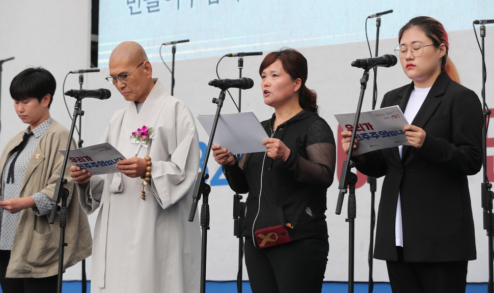 태안화력 하청 비정규직 노동자 고 김용균씨의 어머니 김미숙씨(오른쪽 둘째)가 10일 오전 서울 용산구 민주인권기념관(옛 남영동 대공분실)에서 열린 제32주년 6·10민주항쟁 기념식에서 무대에 올라 산업재해를 막을 수 있는 법 제도를 만들어 달라는 내용을 담은 국민의 소리를 읽고 있다. 백소아 기자