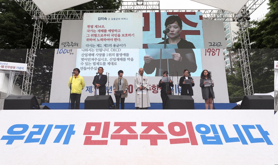 태안화력 하청 비정규직 노동자 고 김용균씨의 어머니 김미숙씨(오른쪽 셋째)가 10일 오전 서울 용산구 민주인권기념관(옛 남영동 대공분실)에서 열린 제32주년 6·10민주항쟁 기념식에서 무대에 올라 산업재해를 막을 수 있는 법 제도를 만들어 달라는 내용을 담은 국민의 소리를 읽고 있다. 백소아 기자 thanks@hani.co.kr