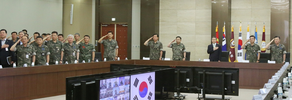 정경두 국방부 장관을 비롯한 국방부, 합참 및 각 군 본부 주요 직위자들이 12일 합참 대회의실에서 열린 ‘2019-1차 전작권 전환 추진평가회의’에 앞서 국기에 대해 경례를 하고 있다. 국방부 제공