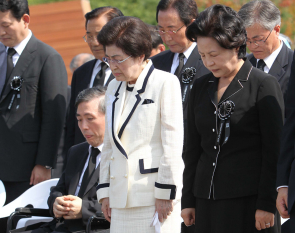 김대중 전 대통령 1주기 추도식에 참석한 김 전 대통령의 부인 이희호 여사(앞줄 오른쪽 둘째)와 노무현 전 대통령의 부인 권양숙 여사(맨 오른쪽) 등이 18일 오전 서울 동작동 국립서울현충원 선양광장에서 고인을 추모하고 있다. 앞줄 왼쪽은 김 전 대통령의 장남 홍일씨. 김태형 기자 xogud555@hani.co.kr