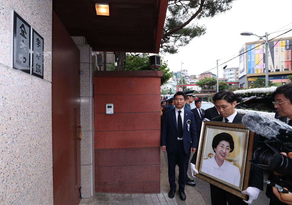 고 이희호 김대중평화센터 이사장의 영정이 14일 오전 서울 동교동 자택 대문 옆에 나란히 걸린 ‘김대중·이희호’ 문패 앞에 잠시 멈춰서 있다. 김정효 기자