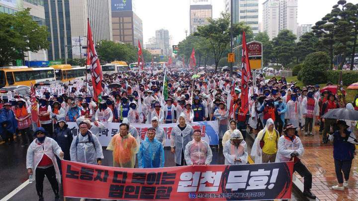 현대중공업의 기습적인 주총장 변경을 통한 법인분할의 원천무효를 촉구하는 거리행진 행렬이 울산시청 앞에 도착해 빗속에 마무리집회를 하고 있다. 민주노총 울산본부 제공