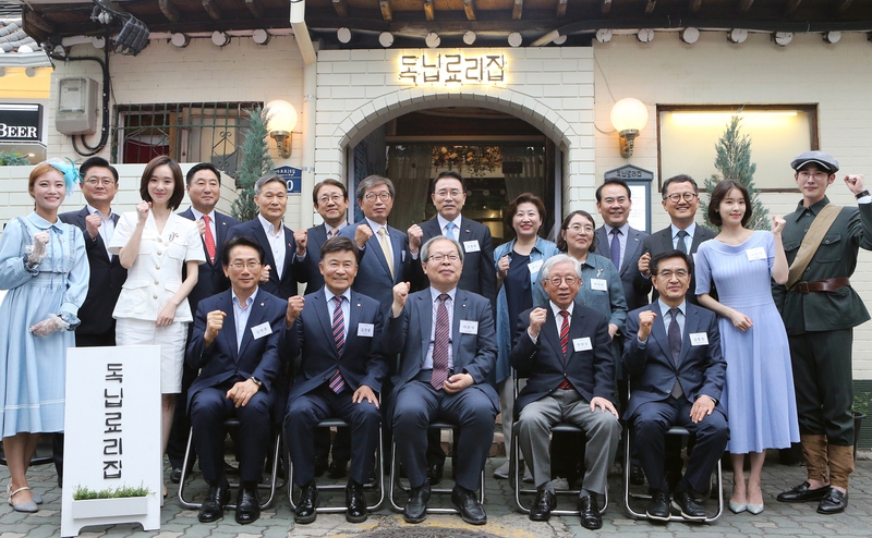 신한희망재단이 서울 종로구 익선동 한옥거리에서 이벤트성으로 19일부터 한달간 ‘독닙료리집’의 문을 연다. 전날 독닙료리집에서 시식행사가 열려 참석자들이 기념사진을 찍고 있다. 앞줄 좌석 왼쪽부터 김영종 종로구청장, 김원웅 광복회 회장, 독립열사 후손 이준식 독립기념관장, 한완상 임시정부 수립 100주년 기념사업추진위원장, 독립열사 후손 김종성씨, 사진 뒷줄 왼쪽에서 여덟번째 조용병 신한희망재단 이사장. 사진 신한희망재단 제공