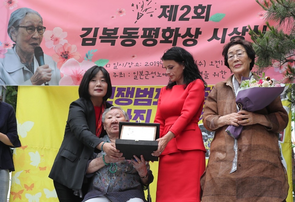 길원옥 할머니(왼쪽 둘째)와 이용수 할머니(맨 오른쪽)가 19일 낮 서울 종로구 옛 일본대사관 터 앞에서 열린 제1392차 일본군 성노예제 문제 해결을 위한 정기 수요시위에서 코소보 내전 생존자 바스피예 크라스니치-굿맨(왼쪽 셋째)에게 제2회 김복동 평화상을 전달하고 있다. 백소아 기자 thanks@hani.co.kr