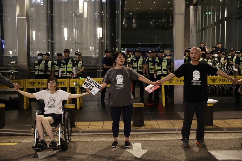 서울 서초구 서초동 삼성 본관 앞에서 ‘문송면·원진노동자 산재사망 30주년 추모와 반올림 1천일 맞이 삼성 포위행동 행사’가 열리던 지난해 7월4일, 한혜경씨와 어머니 김시녀씨가 고 황유미씨의 아버지 황상기씨와 손을 잡고 삼성 본관을 둘러싸고 있다. 반올림은 2015년 10월7일부터 서울 강남역 8번 출구 앞에서 1023일간 천막농성을 진행했다. 김명진 기자 littleprince@hani.co.kr