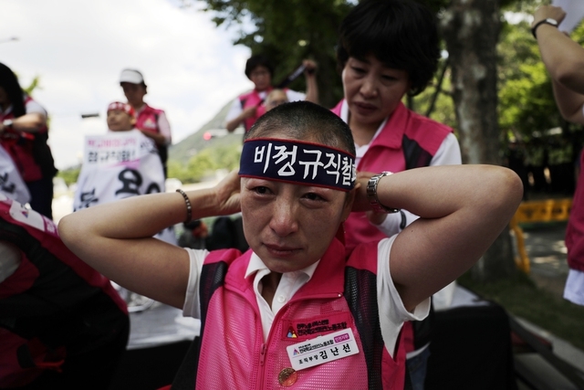 민주노총 전국학교비정규직노동조합 인천지부 김난선 조직부장이 17일 낮 청와대 사랑채 인근 도로에서 정규직화와 정규직 대비 80%로 임금 인상 등을 요구하는 학교 비정규직 여성노동자 100명의 집단 삭발식을 마친 뒤 머리띠를 매고 있다. 김명진 기자 littleprince@hani.co.kr