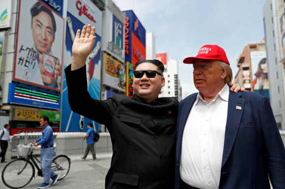 김정은 북한 국무위원장과 도널드 트럼프 미국 대통령을 빼닮은 외모와 분장으로 관심을 끌어온 중국계 오스트레일리아인 하워드 X와 캐나다인 데니스 앨런이 주요 20개국(G20) 정상회의 개막을 이틀 앞둔 26일 일본 오사카 거리에서 포즈를 취하고 있다. 배우인 이들은 지난해 2월 평창 겨울올림픽 때 북한 응원단 앞에 나타나고, 싱가포르 1차 북-미 정상회담 때도 회담장 주변에서 관심을 끌었다. 올해 2월 하노이에서 열린 2차 북-미 정상회담 때도 나타났지만, 하워드 X는 베트남 당국에 의해 추방당했다. 오사카/로이터 연합뉴스