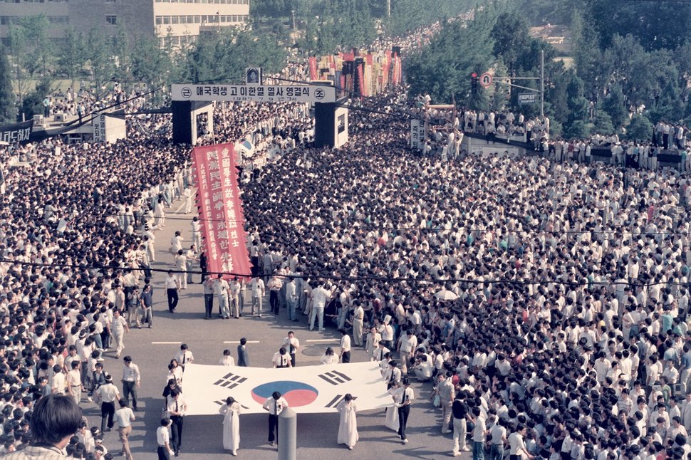 1987년 6월 군사정권에 항거하는 시위 도중 경찰이 쏜 최루탄에 맞아 쓰러진 연세대생 고 이한열 열사의 장례식 전후 상황이 당시 서울에서 근무하던 외신기자의 카메라에 담겼다가 국내에 처음 공개됐다. 14일 이한열기념사업회에 따르면 언론인 출신 주리시 대만정치대 한국어과 교수는 이 열사가 숨진 1987년 7월 5일부터 장례식이 열린 9일까지 시위 등을 촬영한 사진 등 약 300장을 CD에 담아 지난 5일 기념사업회에 보냈다. 사진은 1987년 7월9일 이한열 열사의 영결식 전경. 주리시 교수 촬영·이한열기념사업회 페이스북 갈무리