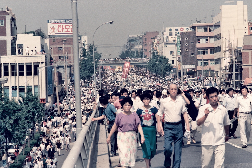 1987년 6월 군사정권에 항거하는 시위 도중 경찰이 쏜 최루탄에 맞아 쓰러진 연세대생 고 이한열 열사의 장례식 전후 상황이 당시 서울에서 근무하던 외신기자의 카메라에 담겼다가 국내에 처음 공개됐다. 14일 이한열기념사업회에 따르면 언론인 출신 주리시 대만정치대 한국어과 교수는 이 열사가 숨진 1987년 7월 5일부터 장례식이 열린 9일까지 시위 등을 촬영한 사진 등 약 300장을 CD에 담아 지난 5일 기념사업회에 보냈다. 사진은 아현고가를 지나는 장례행렬. 주리시 교수 촬영·이한열기념사업회 제공