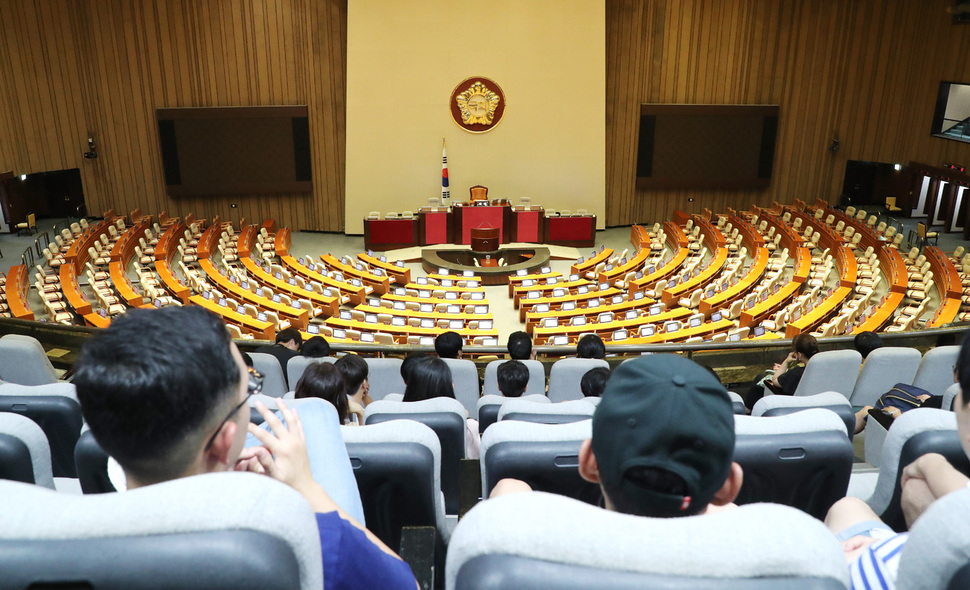 6월 임시국회 회기 마지막날인 19일 오후 국회 관람석에서 시민들이 텅 빈 본회의장을 바라보고 있다. 이날 추가경정예산안 처리와 북한 목선 입항 사건 국정조사 등을 둘러싸고 교섭단체 3당 원내대표가 협상을 벌였지만 종일 진통을 겪었다. 연합뉴스