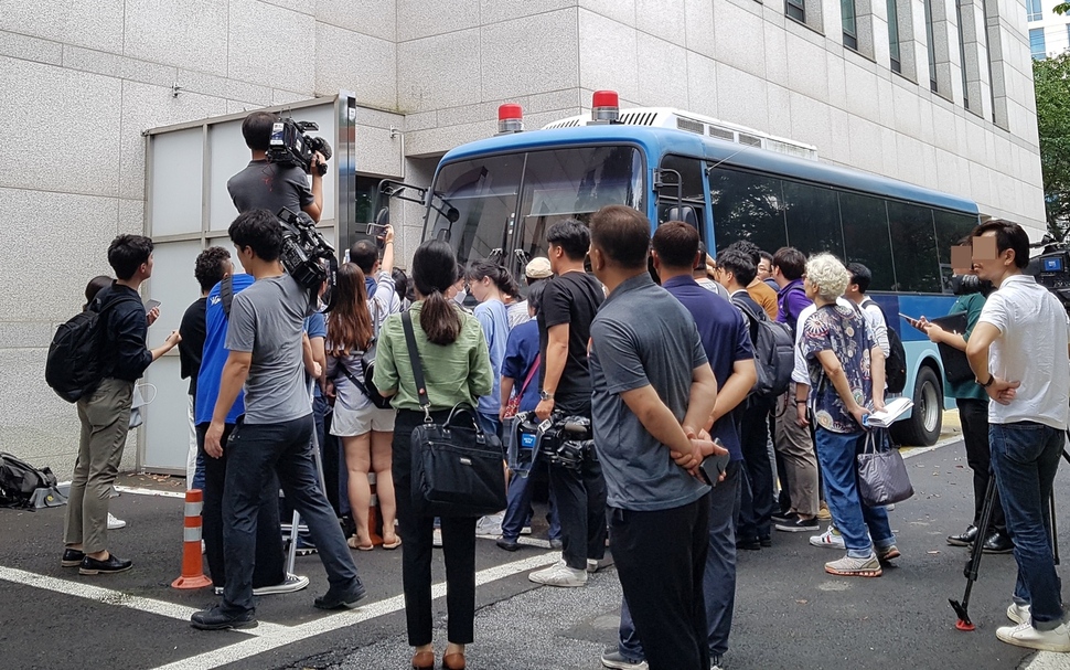 제주 ‘전남편 살해사건’ 피의자 고아무개씨가 12일 재판이 끝나고 호송차에 오르는 모습을 지켜보기 위해 주민들과 취재기자들이 호송차 주변에 몰려들었다.