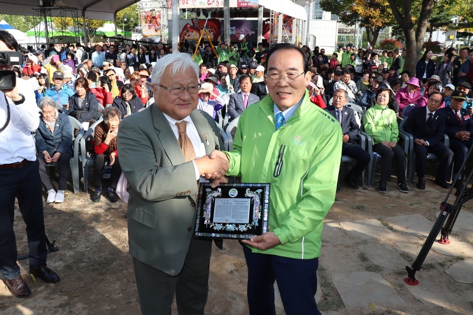 정상혁 보은군수(오른쪽)가 지난 2017년 10월 보은 평화의 소녀상 제막식에서 마이크 혼다 전 의원에게 감사패를 건네고 있다. 오윤주 기자