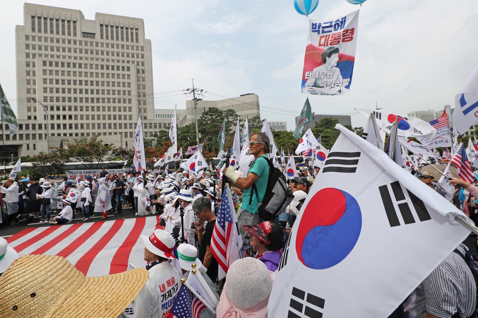 박근혜 전 대통령과 최순실씨의 ‘국정농단’ 사건에 대한 대법원 판결이 예정된 29일 오후 서울 서초구 대법원 앞에서 태극기를 든 시민들이 선고 결과를 기다리고 있다. 연합뉴스