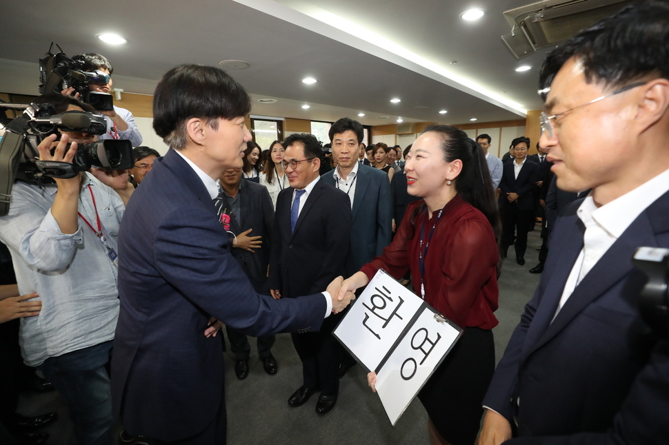 조국 신임 법무부 장관이 9일 오후 정부과천청사에서 열린 취임식에서 ‘환영’ 손팻말을 든 직원과 인사하고 있다. 과천/공동취재사진