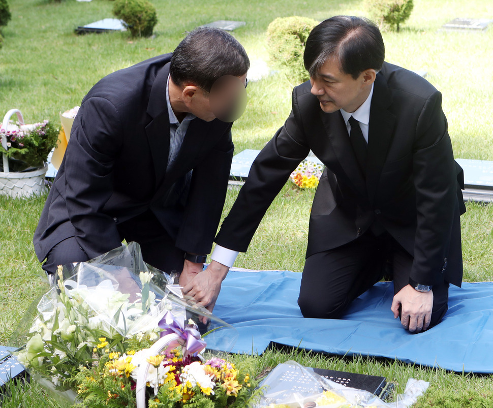 조국 법무부 장관이 14일 오전 부산 기장군 부산추모공원에 안장된 고 김홍영 전 검사 묘소에서 김 전 검사 부친의 손을 잡고 위로하고 있다. 김 전 검사는 서울남부지검 형사부에 근무하던 2016년 5월 업무 스트레스와 직무 압박감을 토로하는 내용의 유서를 남기고 서른셋의 나이에 목숨을 끊었다. 2019.9.14. 연합뉴스