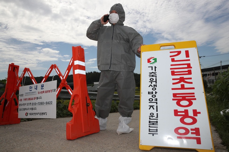 돼지 전염병인 아프리카돼지열병(ASF)이 발생한 경기도 파주시의 한 양돈농장에 들어가는 길목에서 17일 오전 방역관련 관계자들이 일반인 출입을 통제하고 있다. 파주/김봉규 선임기자 bong9@hani.co.kr