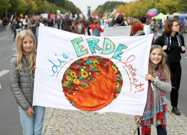 유엔 기후행동 정상회의를 사흘 앞둔 20일, 독일의 수도 베를린에서 열린 전세계 릴레이 ‘기후 파업’에 참석한 두 소녀가 ‘지구가 불타고 있어요’라고 적힌 펼침막을 들고 기후변화에 대한 대책 마련을 촉구하고 있다. 베를린/EPA 연합뉴스