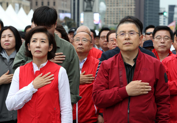 황교안 자유한국당 대표와 나경원 원내대표가 21일 오후 서울 광화문 세종문화회관에서 열린 ‘문재인 정권 헌정 유린 중단과 위선자 조국 파면 촉구’ 집회에 참석해 국기에 경례하고 있다. 연합뉴스